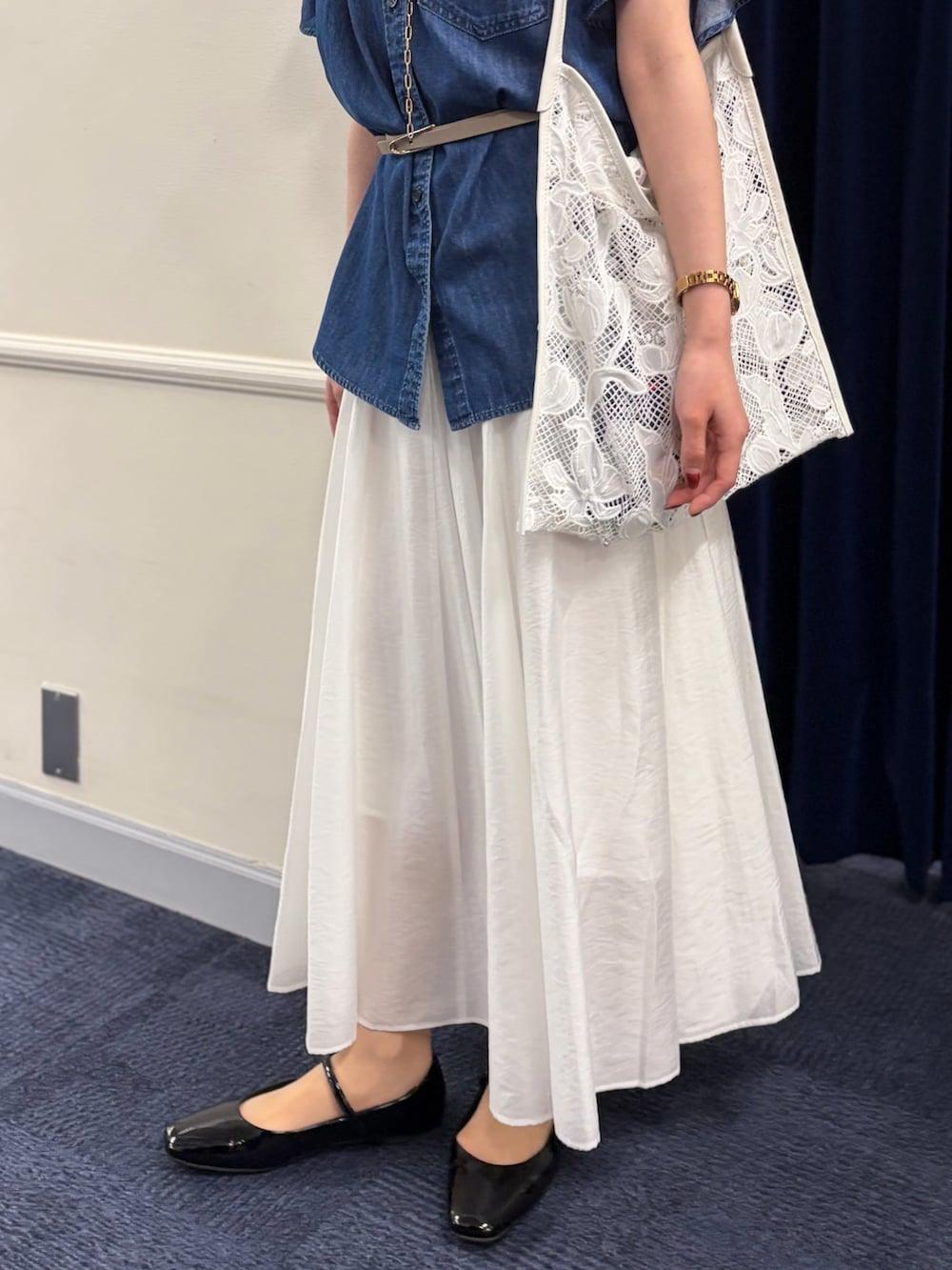 ブルー系のシャツ/ブラウス、ホワイト系のスカート、ブラック系のパンプスを着用したレディースの春コーディネートの6枚目の写真