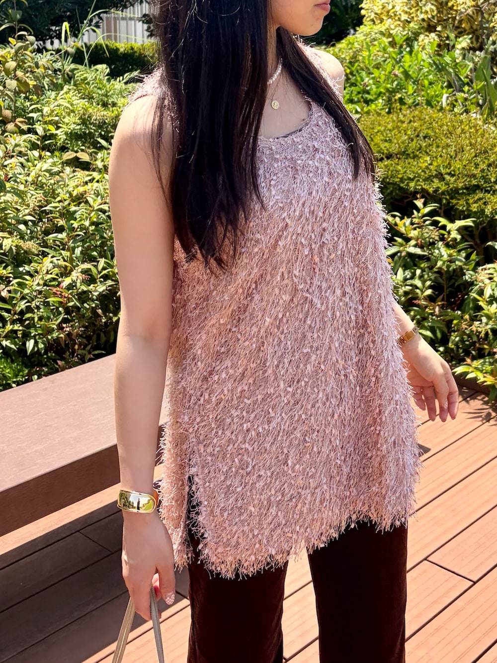 ピンク系のベスト、ブラウン系のその他パンツ、ベージュ系のショルダーバッグを着用したレディースの夏コーディネートの6枚目の写真