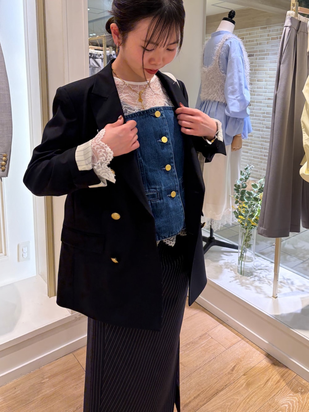 グレー系のトートバッグ、ブルー系のテーラードジャケット、ブルー系のキャミソールを着用したレディースの冬コーディネートの6枚目の写真