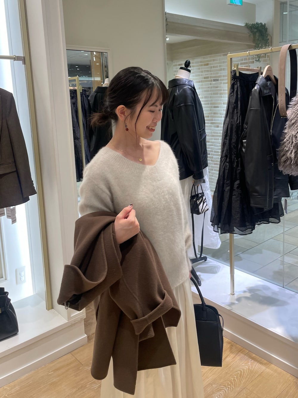 ベージュ系のニット/セーター、ブラウン系のその他アウター、ブラック系のショルダーバッグを着用したレディースの秋コーディネートの6枚目の写真