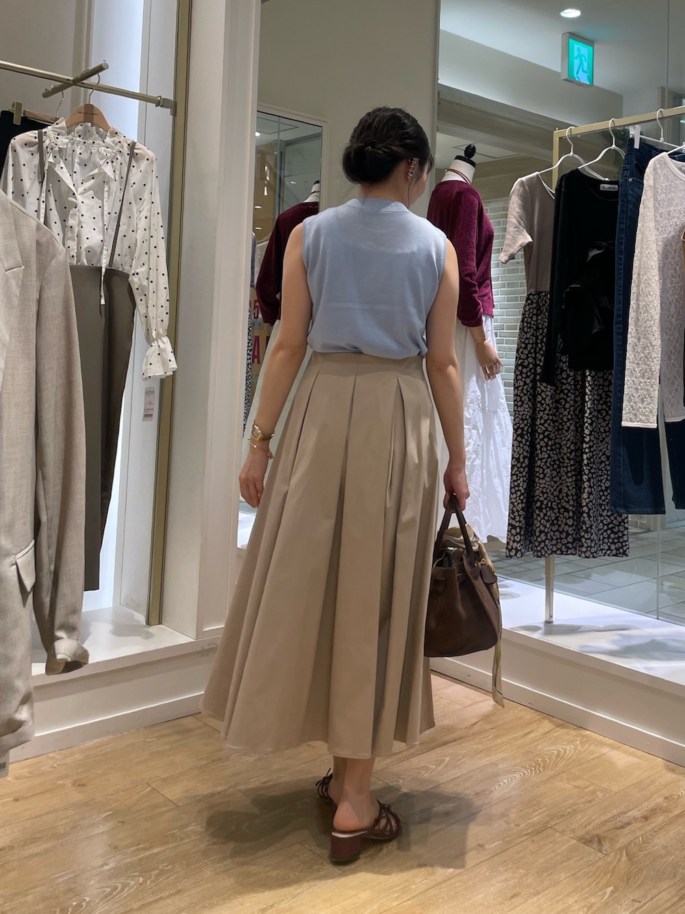 ブルー系のニット/セーター、ベージュ系のスカートを着用したレディースの秋コーディネートの5枚目の写真