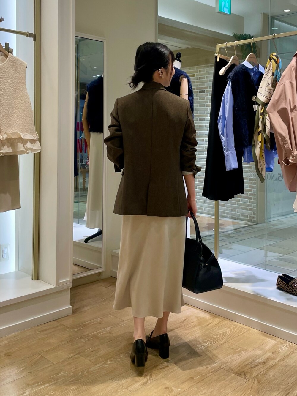 ブラウン系のテーラードジャケット、イエロー系のニット/セーター、ブラック系のショルダーバッグを着用したレディースの秋コーディネートの3枚目の写真