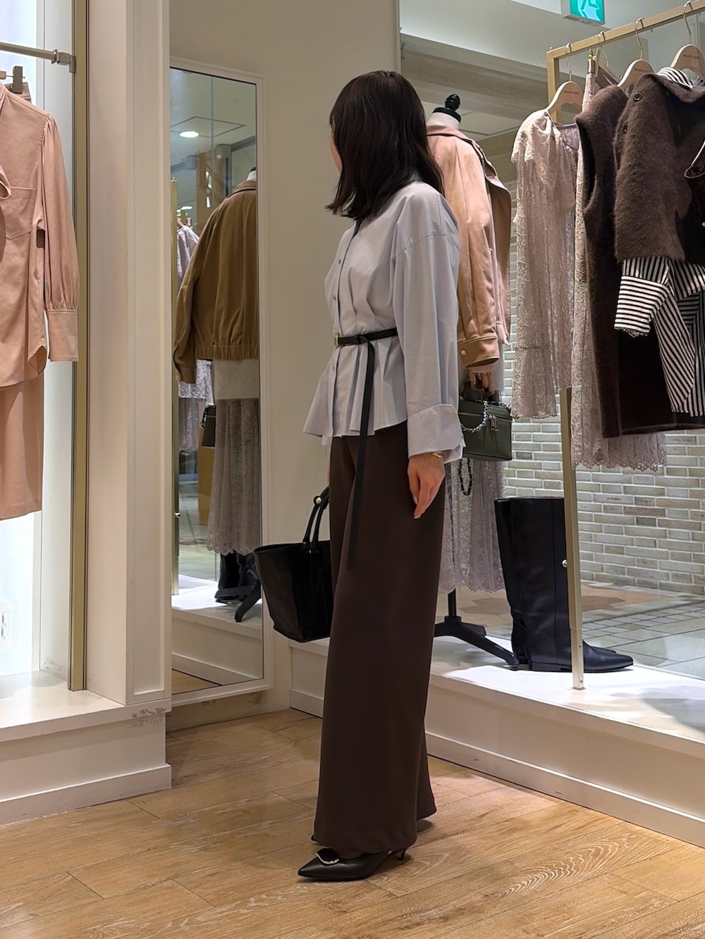 ブルー系のシャツ/ブラウス、ブラウン系のその他パンツ、ブラック系のトートバッグを着用したレディースの秋コーディネートの2枚目の写真