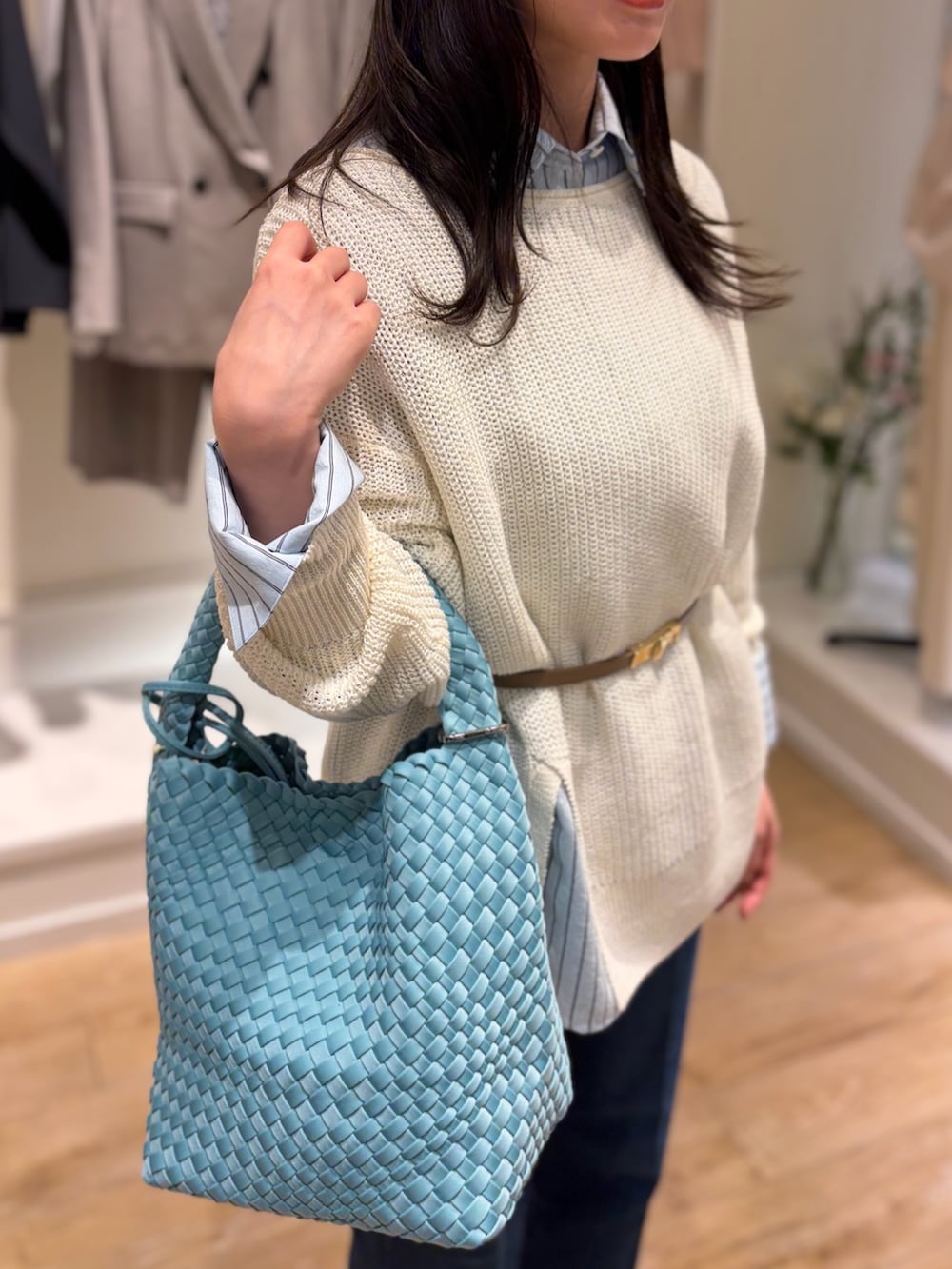 ブルー系のシャツ/ブラウス、ホワイト系のニット/セーター、ブルー系のショルダーバッグを着用したレディースの冬コーディネートの5枚目の写真