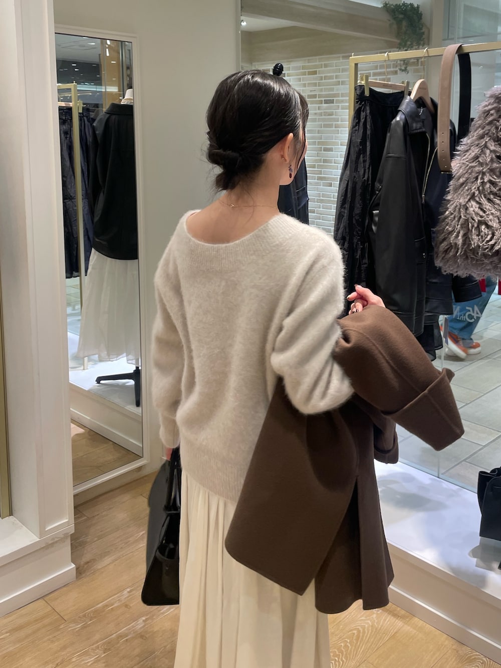 ベージュ系のニット/セーター、ブラウン系のその他アウター、ブラック系のショルダーバッグを着用したレディースの秋コーディネートの7枚目の写真