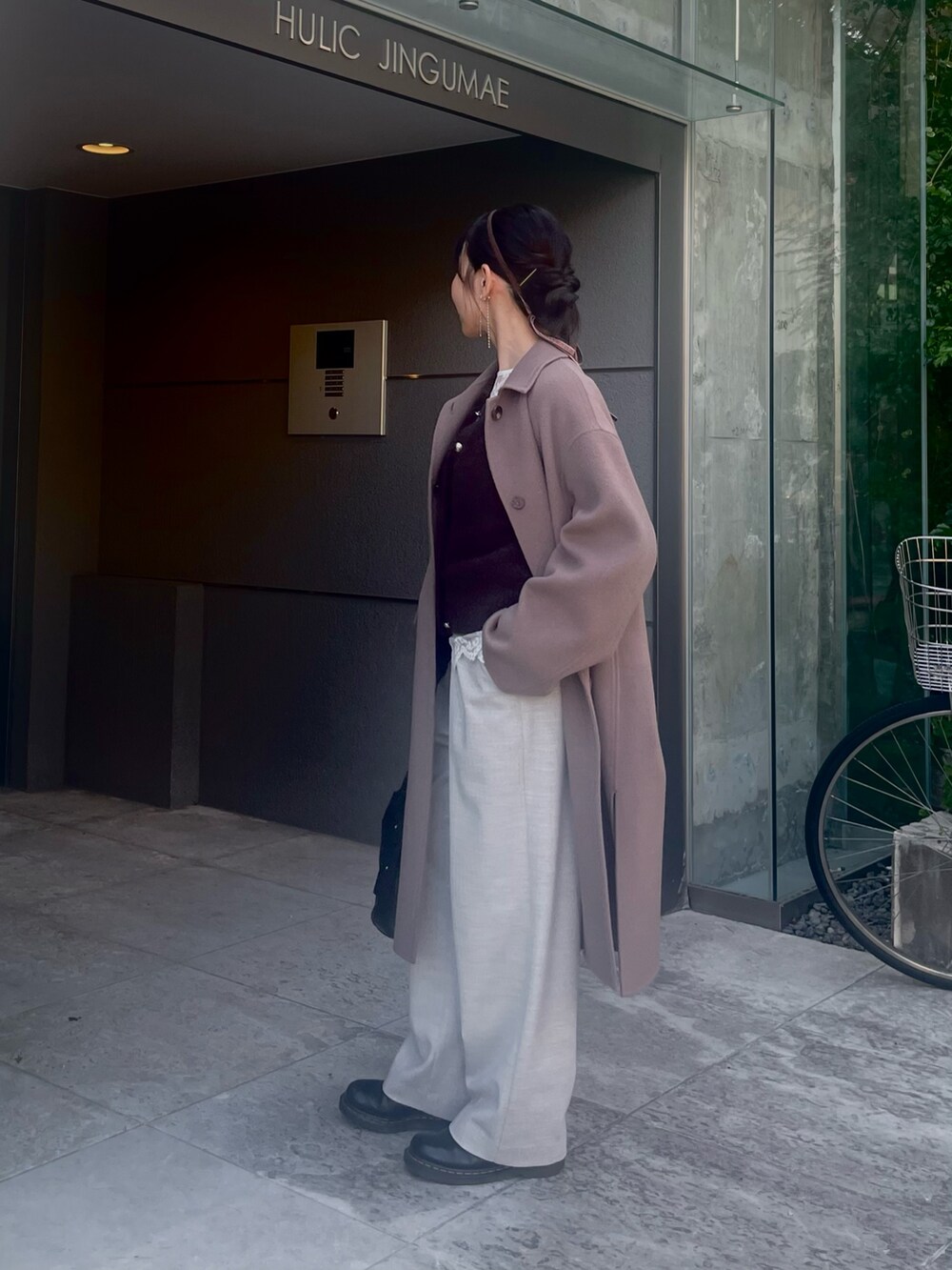 グリーン系のステンカラーコート、ブラウン系のカーディガン/ボレロ、ホワイト系のシャツ/ブラウスを着用したレディースの秋コーディネートの2枚目の写真