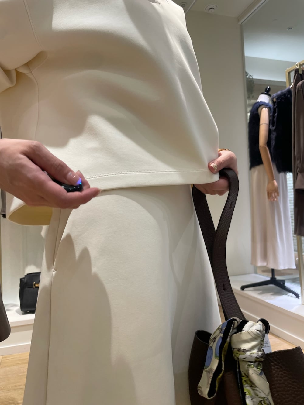 ブラウン系のショルダーバッグ、グリーン系のネクタイ、ホワイト系のTシャツ/カットソーを着用したレディースの秋コーディネートの6枚目の写真