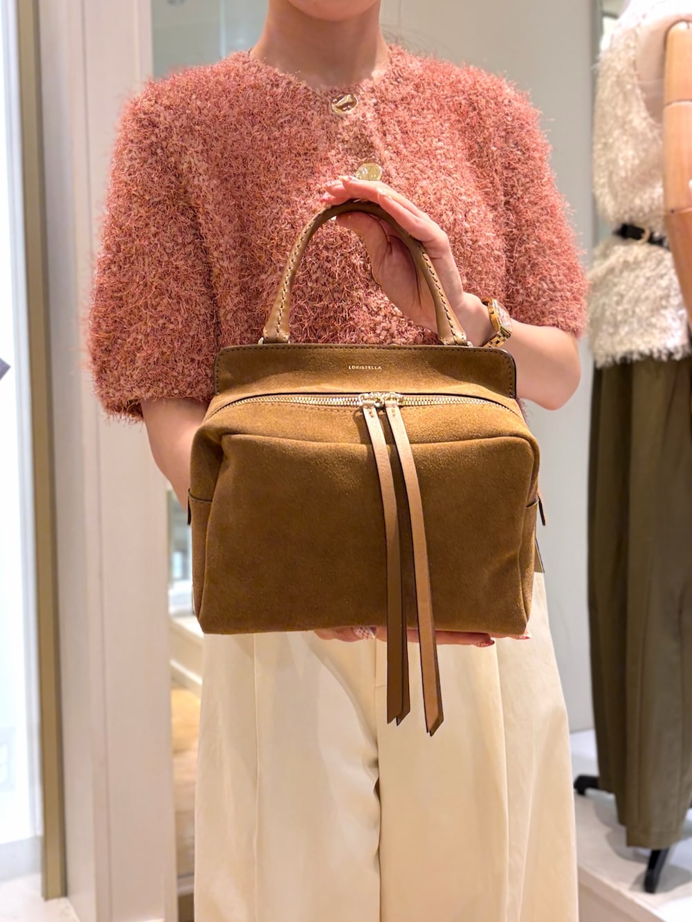 ピンク系のニット/セーター、ホワイト系のチノパンツ、イエロー系のショルダーバッグを着用したレディースの秋コーディネートの7枚目の写真