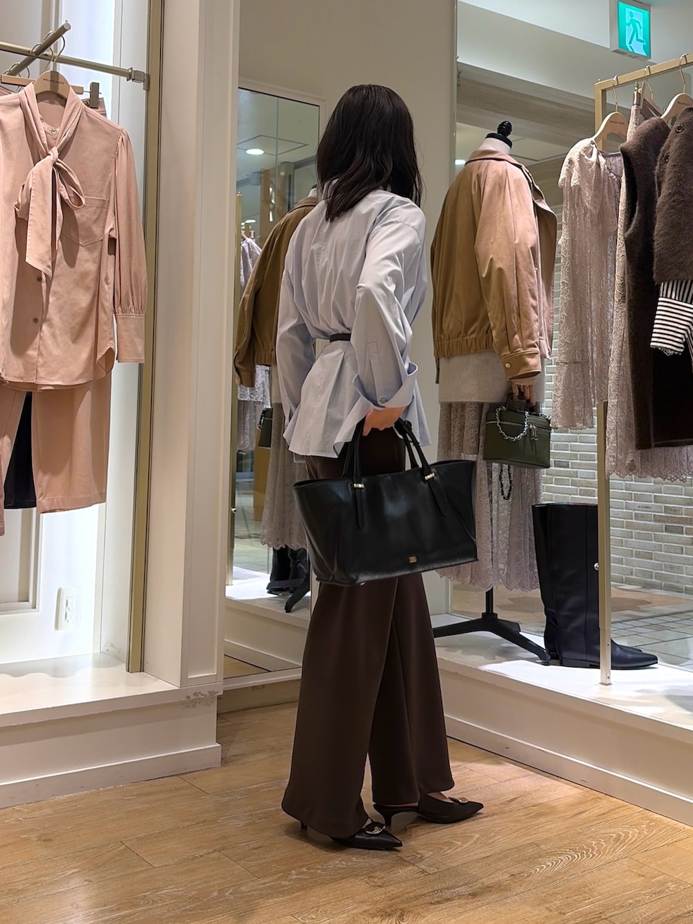 ブルー系のシャツ/ブラウス、ブラウン系のその他パンツ、ブラック系のトートバッグを着用したレディースの秋コーディネートの4枚目の写真