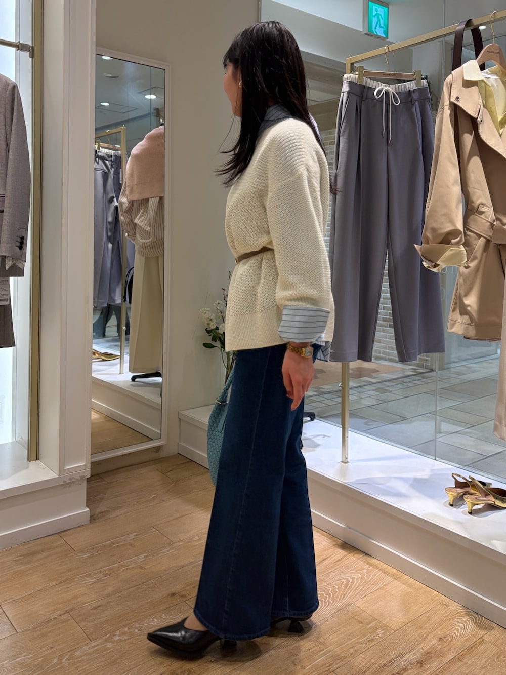 ベージュ系のステンカラーコート、ブルー系のシャツ/ブラウス、ホワイト系のニット/セーターを着用したレディースの冬コーディネートの6枚目の写真