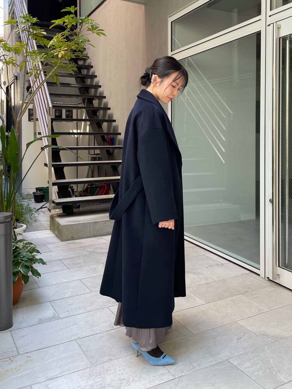 ブルー系のニット/セーター、ベージュ系のトートバッグ、グリーン系のスカートを着用したレディースの秋コーディネートの5枚目の写真