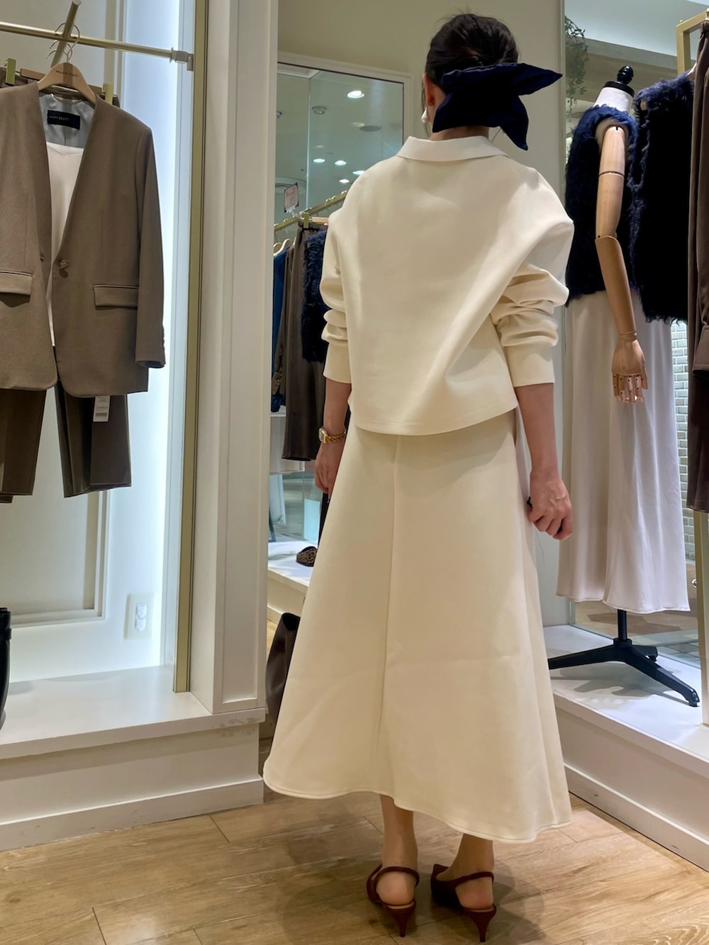 ブラウン系のショルダーバッグ、グリーン系のネクタイ、ホワイト系のTシャツ/カットソーを着用したレディースの秋コーディネートの3枚目の写真