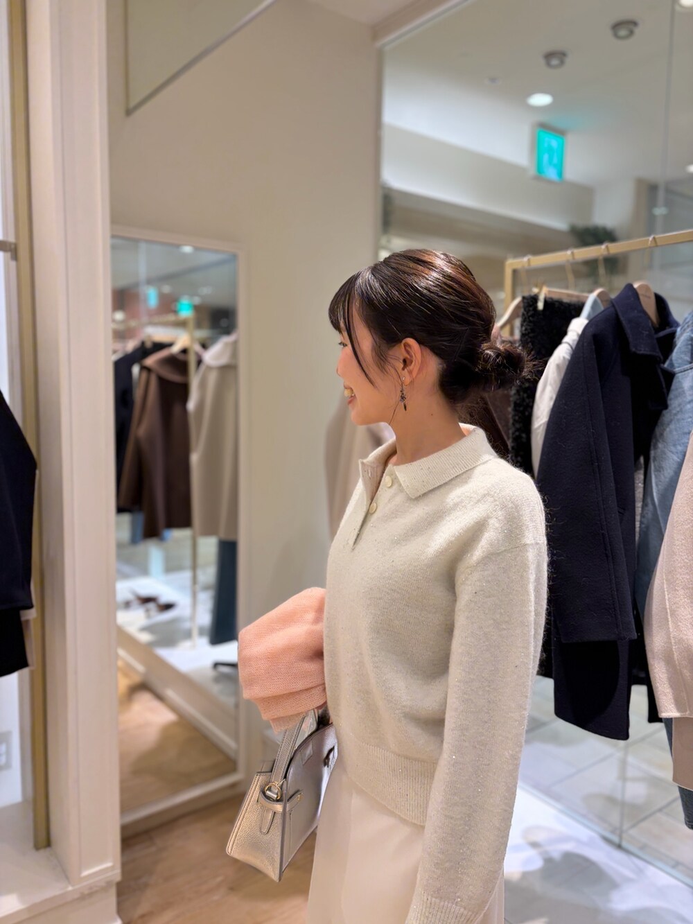 ホワイト系のニット/セーター、シルバー系のショルダーバッグ、ホワイト系のスカートを着用したレディースの秋コーディネートの5枚目の写真