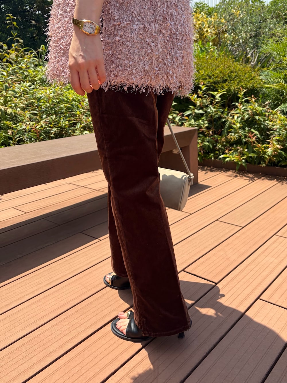 ピンク系のベスト、ブラウン系のその他パンツ、ベージュ系のショルダーバッグを着用したレディースの夏コーディネートの10枚目の写真