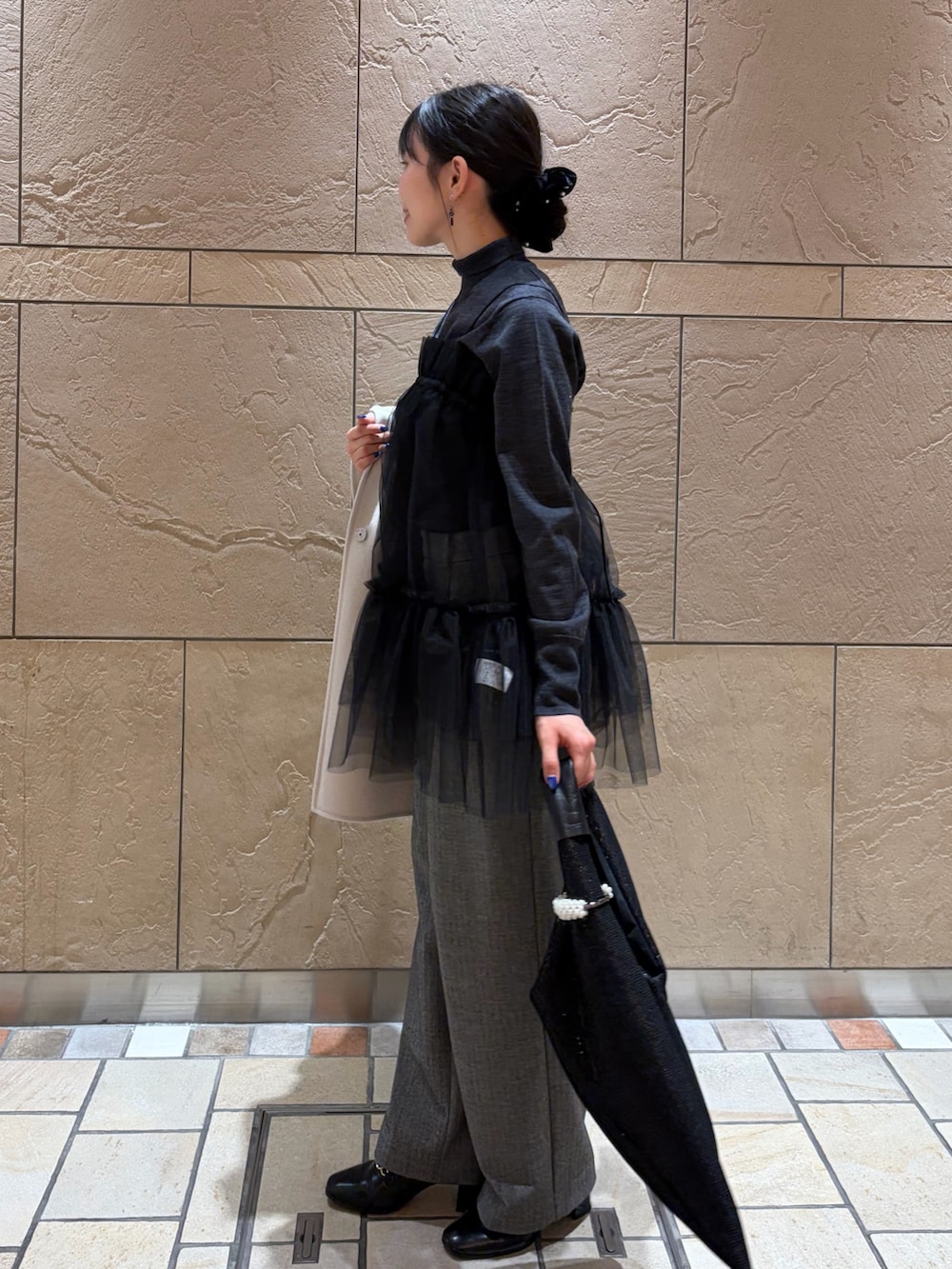 ベージュ系のステンカラーコート、グレー系のニット/セーター、ブラック系のキャミソールを着用したレディースの冬コーディネートの7枚目の写真