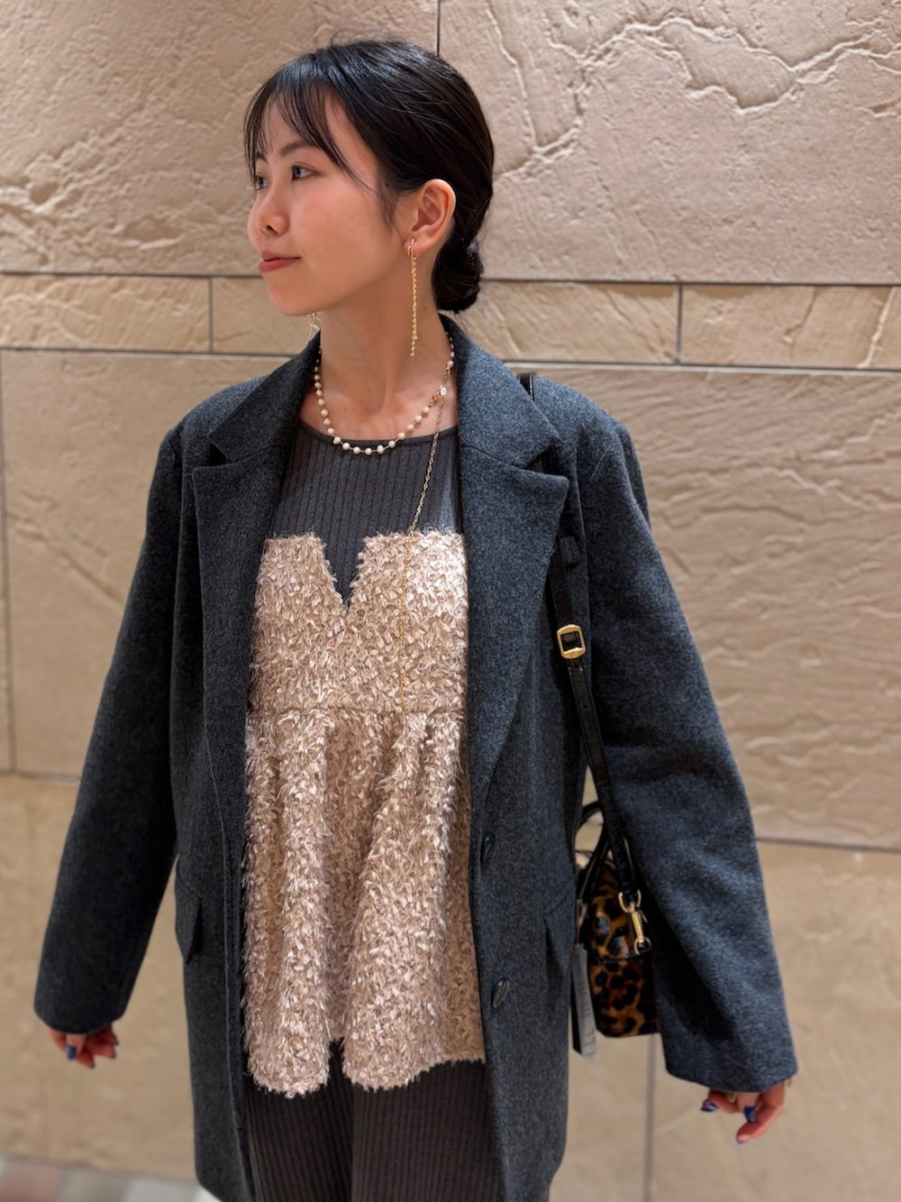 グレー系のテーラードジャケット、その他のボストンバッグ、ベージュ系のキャミソールを着用したレディースの冬コーディネートの6枚目の写真