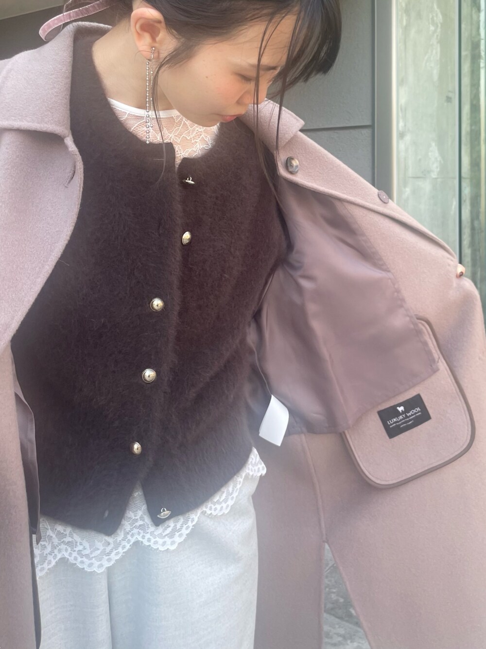 グリーン系のステンカラーコート、ブラウン系のカーディガン/ボレロ、ホワイト系のシャツ/ブラウスを着用したレディースの秋コーディネートの4枚目の写真