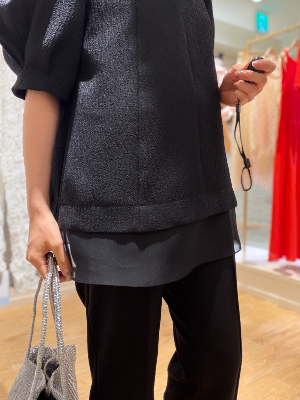 ブラック系のシャツ/ブラウス、シルバー系のかごバッグ、ブラック系のその他パンツを着用したレディースの春コーディネートの6枚目の写真