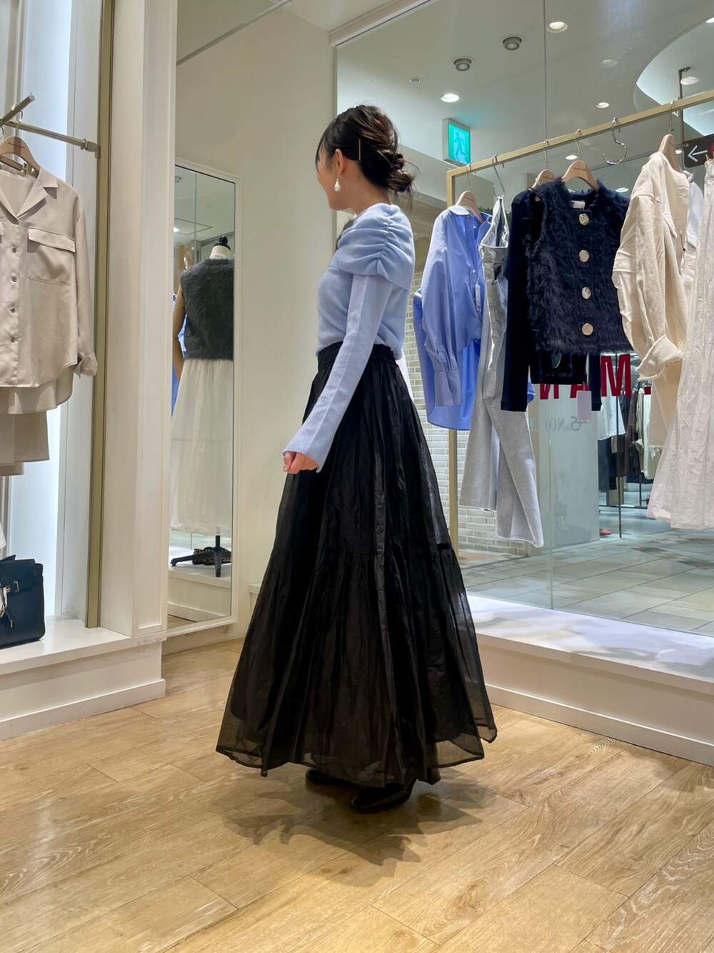 グレー系のニット/セーター、ベージュ系のショルダーバッグを着用したレディースの秋コーディネートの3枚目の写真