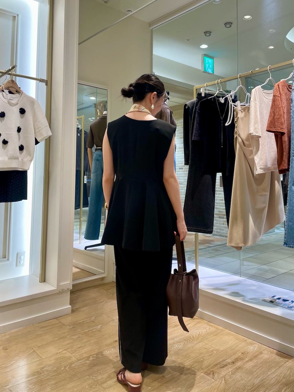 ブラック系のその他パンツ、ブラック系のタンクトップ、ブラウン系のショルダーバッグを着用したレディースの秋コーディネートの3枚目の写真