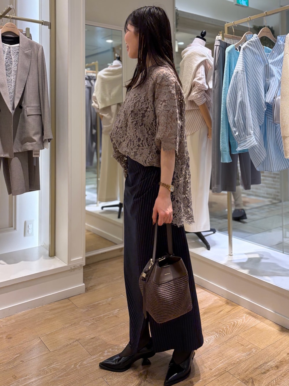 ブルー系のスカート、ブラウン系のショルダーバッグ、その他のネックレスを着用したレディースの冬コーディネートの3枚目の写真