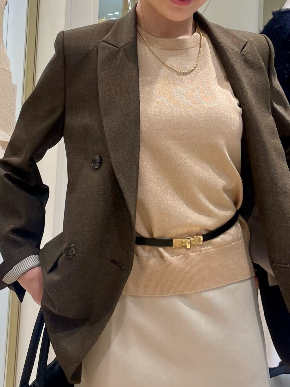 ブラウン系のテーラードジャケット、イエロー系のニット/セーター、ブラック系のショルダーバッグを着用したレディースの秋コーディネートの6枚目の写真