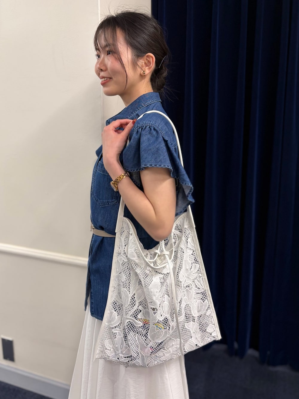 ブルー系のシャツ/ブラウス、ホワイト系のスカート、ブラック系のパンプスを着用したレディースの春コーディネートの7枚目の写真