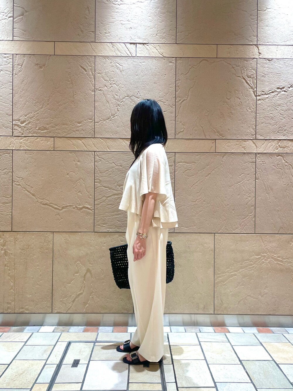 ベージュ系のニット/セーター、ホワイト系のその他パンツ、ブラック系のかごバッグを着用したレディースの夏コーディネートの2枚目の写真