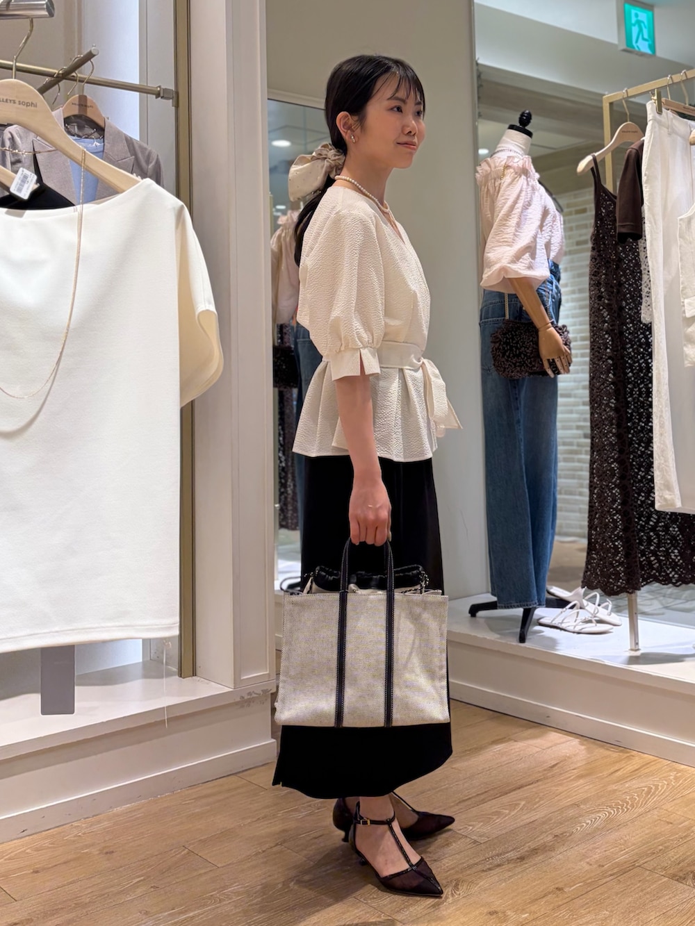 ホワイト系のシャツ/ブラウス、ブラック系のスカート、ブラック系のトートバッグを着用したレディースの春コーディネートの5枚目の写真