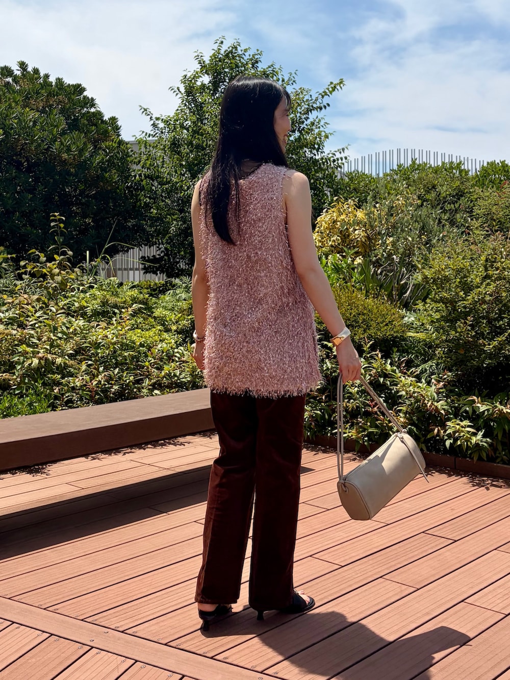 ピンク系のベスト、ブラウン系のその他パンツ、ベージュ系のショルダーバッグを着用したレディースの夏コーディネートの5枚目の写真