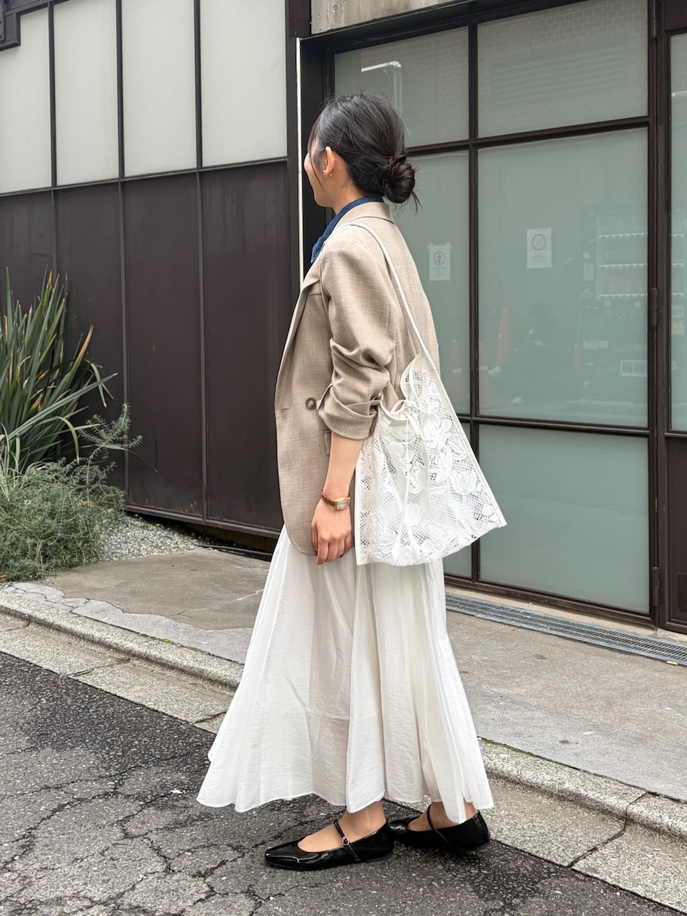 ブルー系のシャツ/ブラウス、ホワイト系のスカート、ベージュ系のテーラードジャケットを着用したレディースの春コーディネートの6枚目の写真