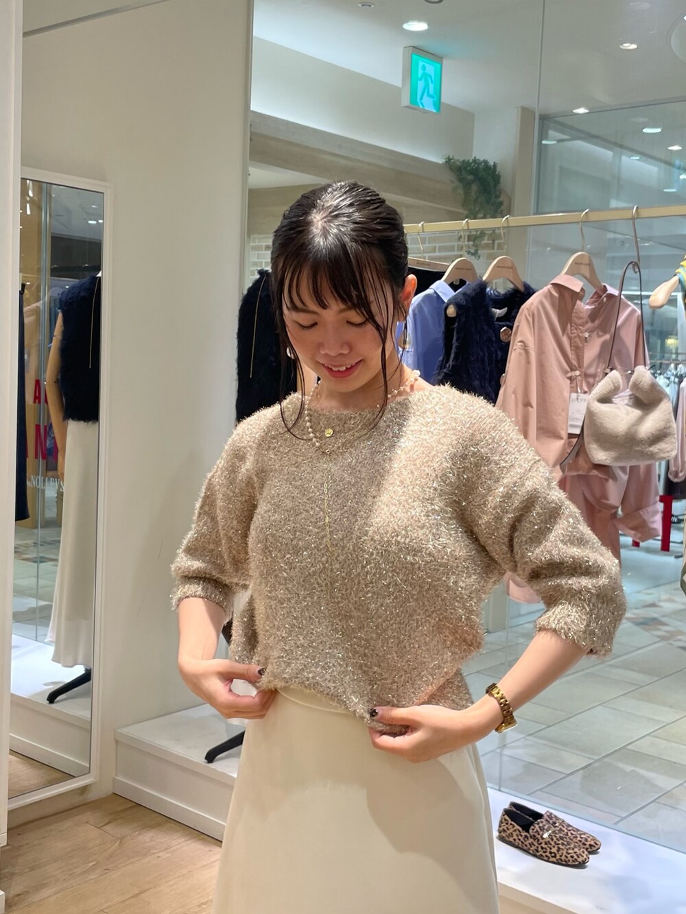 イエロー系のカーディガン/ボレロ、ホワイト系のスカート、ブラウン系のショルダーバッグを着用したレディースの秋コーディネートの9枚目の写真