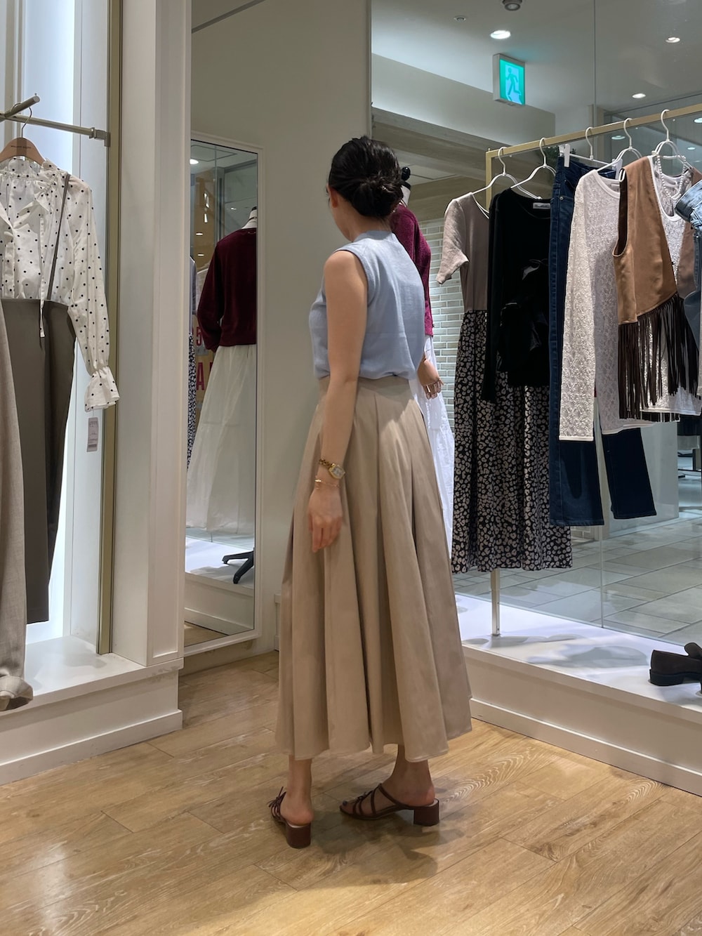 ブルー系のニット/セーター、ベージュ系のスカートを着用したレディースの秋コーディネートの4枚目の写真