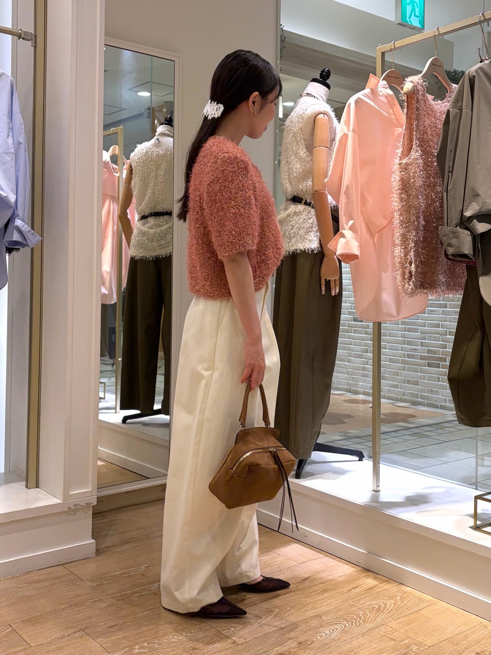 ピンク系のニット/セーター、ホワイト系のチノパンツ、イエロー系のショルダーバッグを着用したレディースの秋コーディネートの5枚目の写真