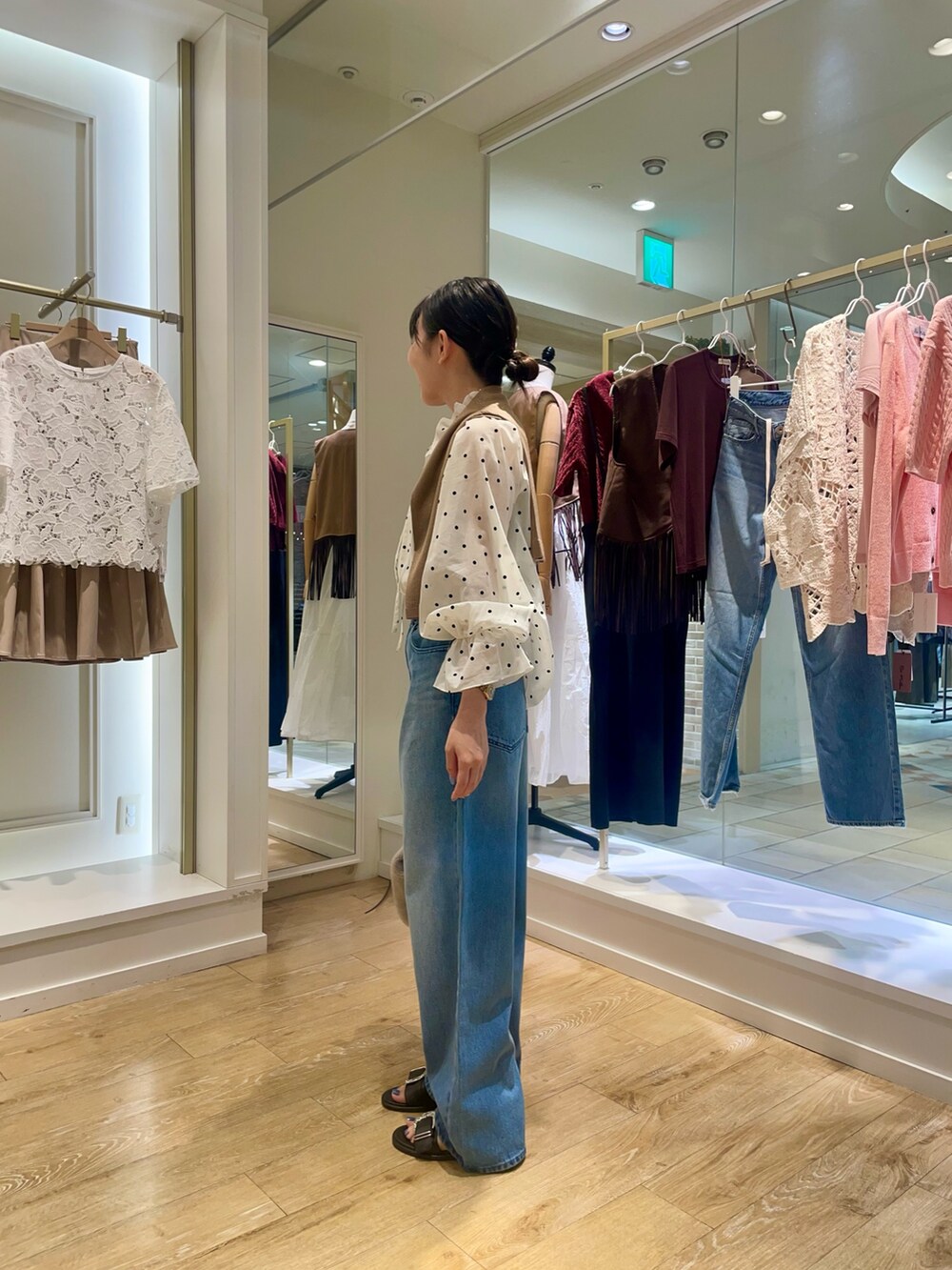 ベージュ系のショルダーバッグ、ブルー系のデニムパンツ、ホワイト系のシャツ/ブラウスを着用したレディースの秋コーディネートの2枚目の写真