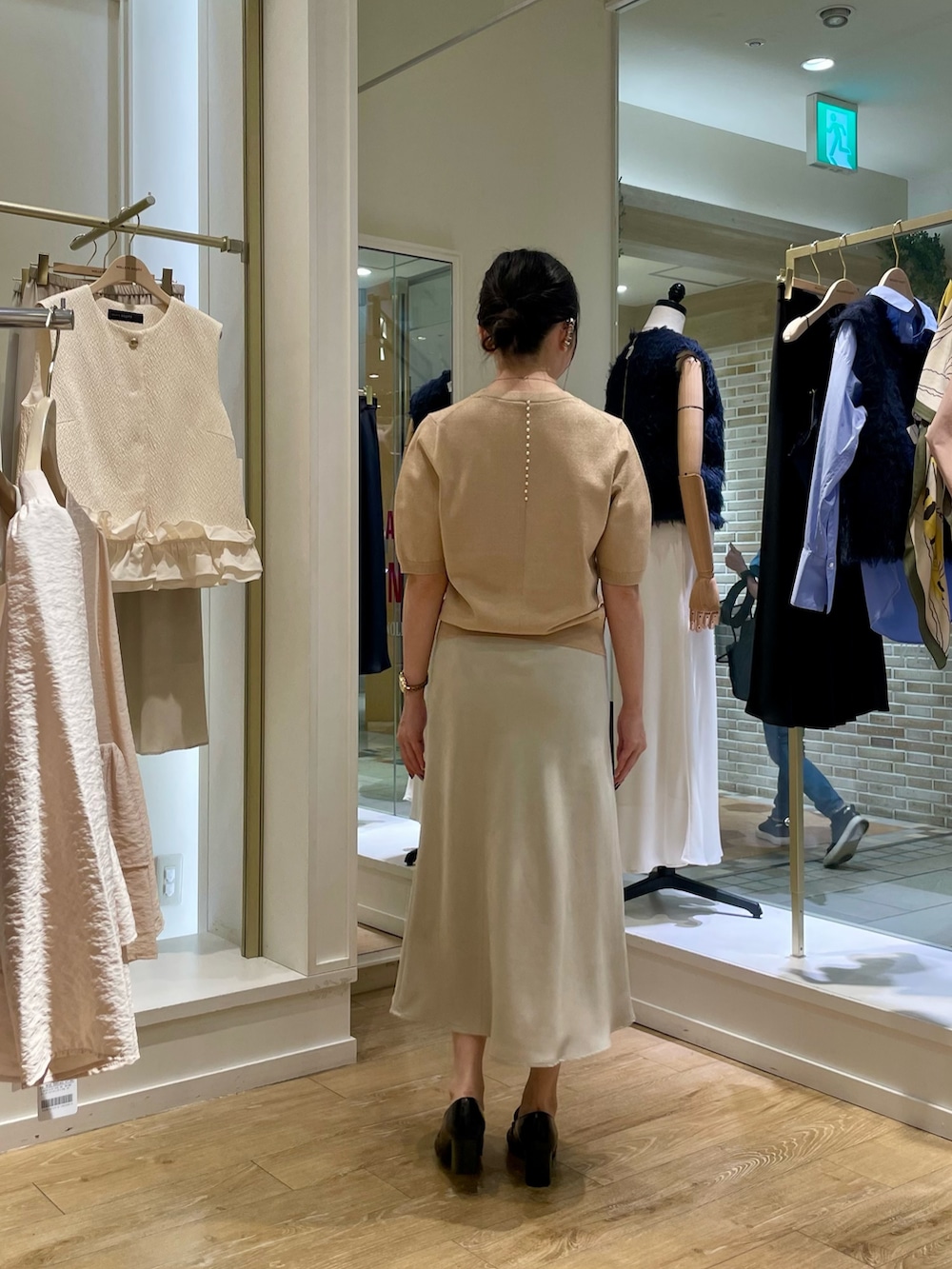 イエロー系のニット/セーター、ベージュ系のスカートを着用したレディースの秋コーディネートの5枚目の写真