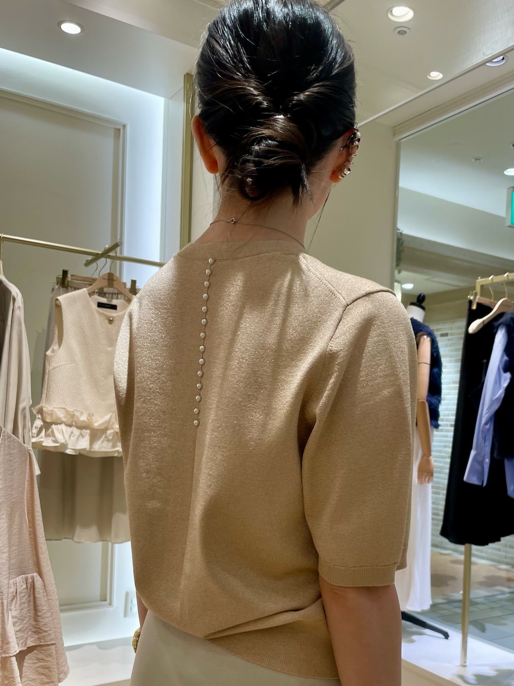 イエロー系のニット/セーター、ベージュ系のスカートを着用したレディースの秋コーディネートの7枚目の写真