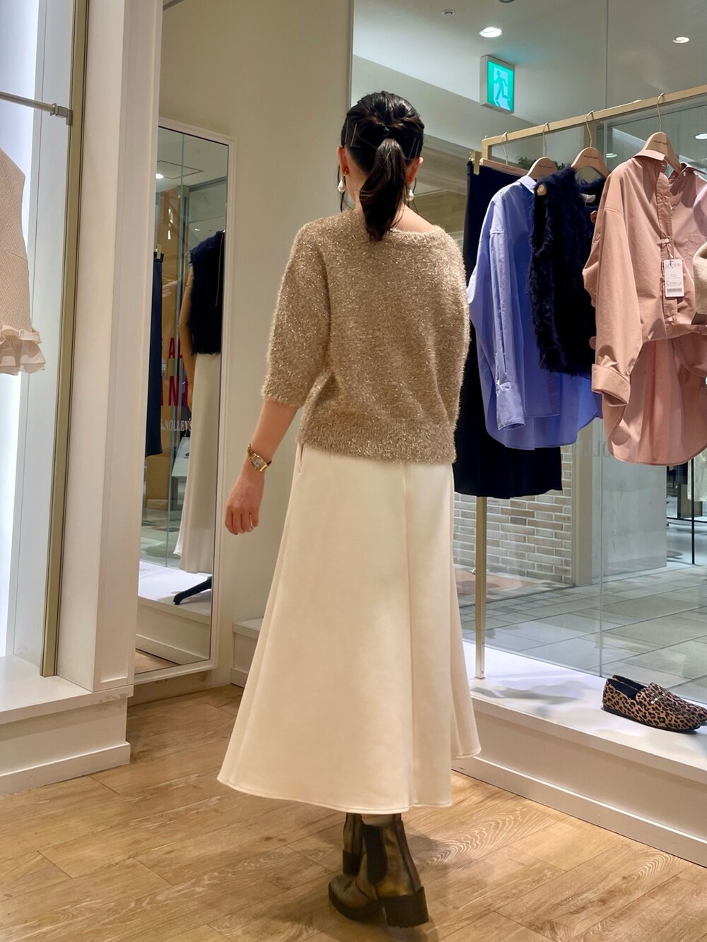 イエロー系のカーディガン/ボレロ、ホワイト系のスカート、ブラウン系のショルダーバッグを着用したレディースの秋コーディネートの4枚目の写真