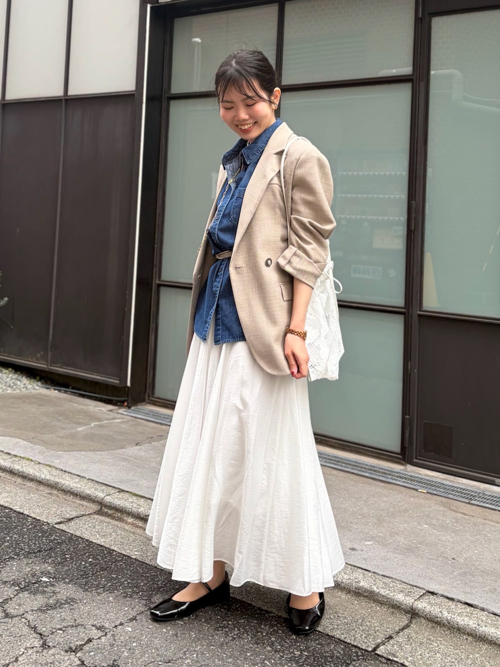 ブルー系のシャツ/ブラウス、ホワイト系のスカート、ベージュ系のテーラードジャケットを着用したレディースの春コーディネートの2枚目の写真