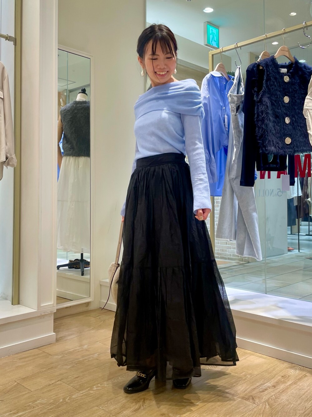 グレー系のニット/セーター、ベージュ系のショルダーバッグを着用したレディースの秋コーディネートの6枚目の写真