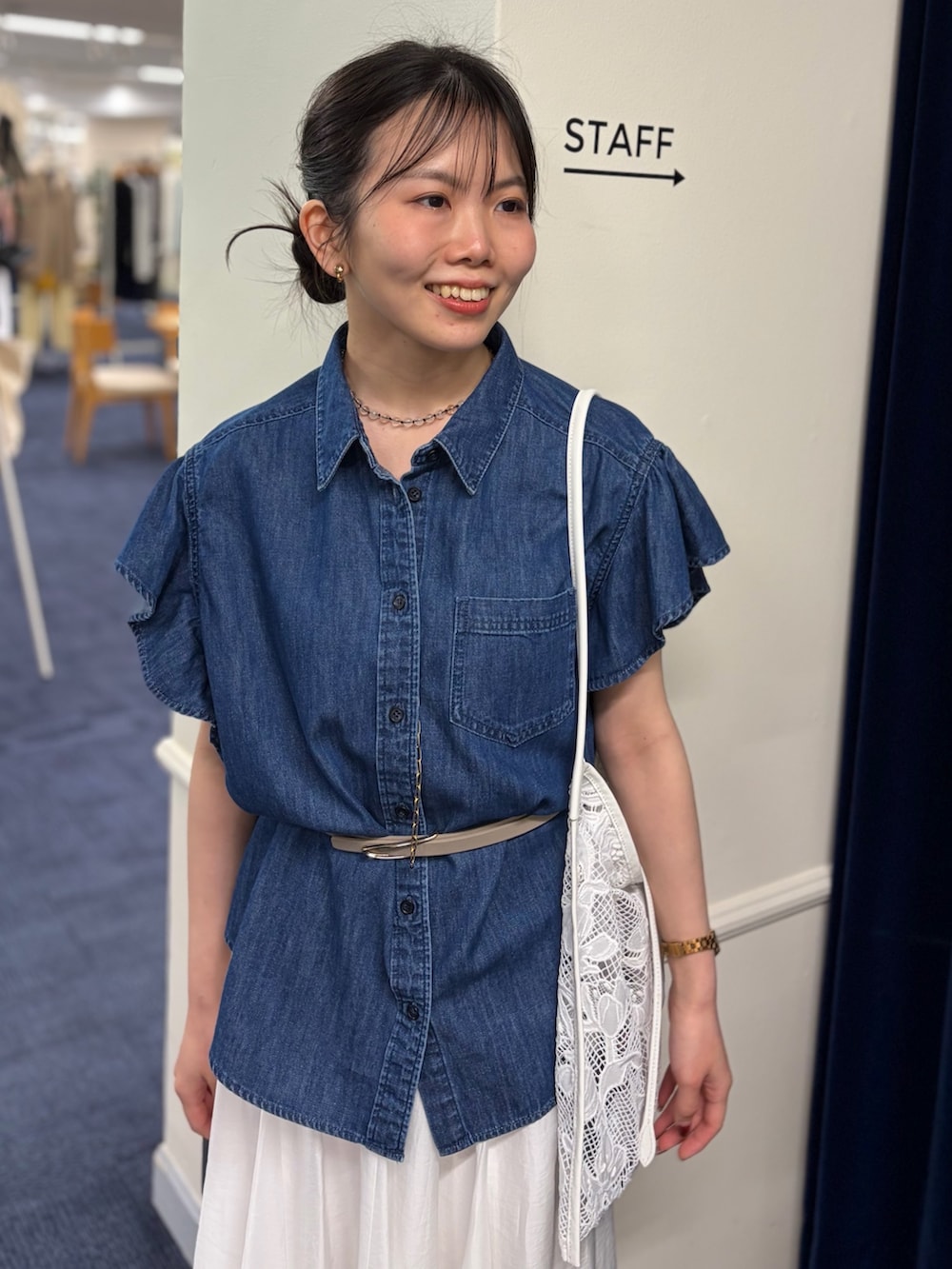 ブルー系のシャツ/ブラウス、ホワイト系のスカート、ブラック系のパンプスを着用したレディースの春コーディネートの5枚目の写真