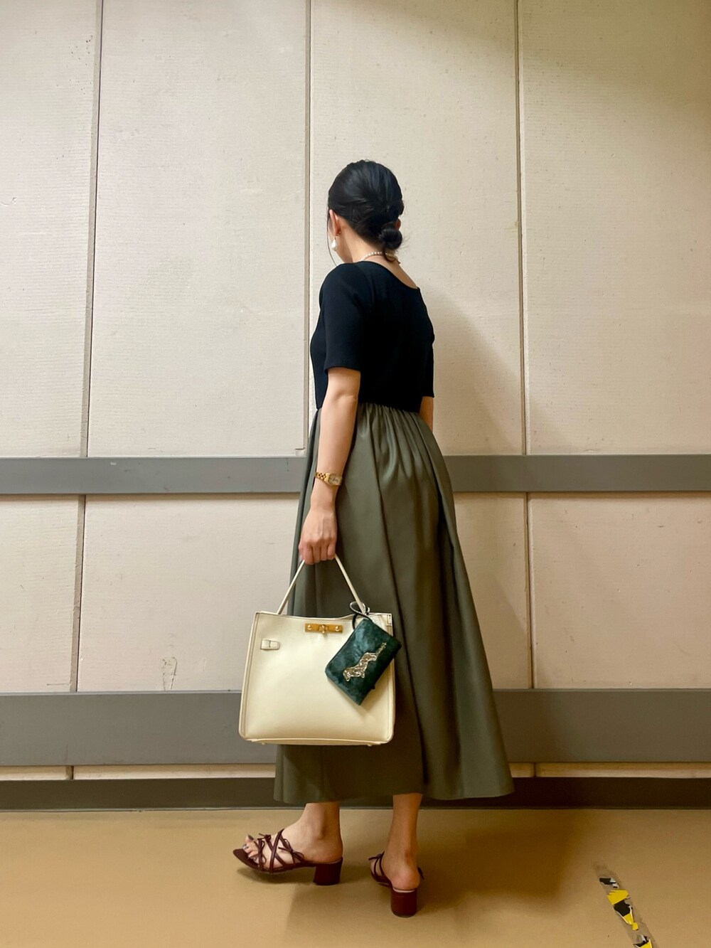 ホワイト系のショルダーバッグ、グリーン系のワンピース、ホワイト系のネックレスを着用したレディースの夏コーディネートの2枚目の写真