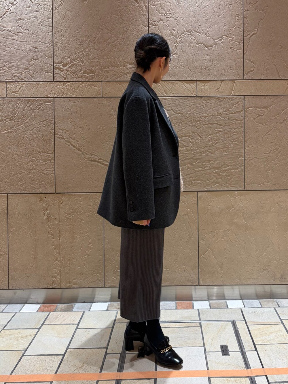 グレー系のテーラードジャケット、その他のボストンバッグ、ベージュ系のキャミソールを着用したレディースの冬コーディネートの4枚目の写真