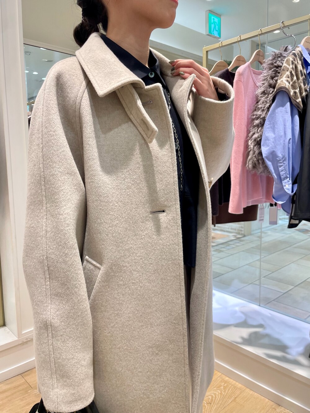 ベージュ系のステンカラーコート、ブルー系のシャツ/ブラウス、ブラック系のトートバッグを着用したレディースの秋コーディネートの9枚目の写真