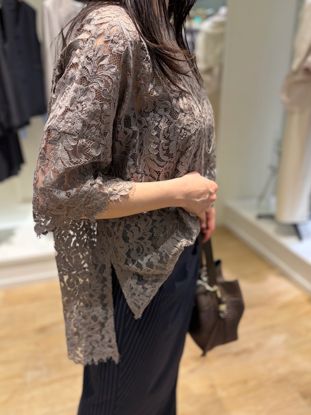 ブルー系のスカート、ブラウン系のショルダーバッグ、その他のネックレスを着用したレディースの冬コーディネートの7枚目の写真