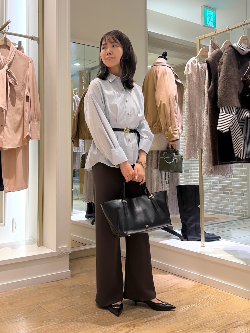 ブルー系のシャツ/ブラウス、ブラウン系のその他パンツ、ブラック系のトートバッグを着用したレディースの秋コーディネートの5枚目の写真