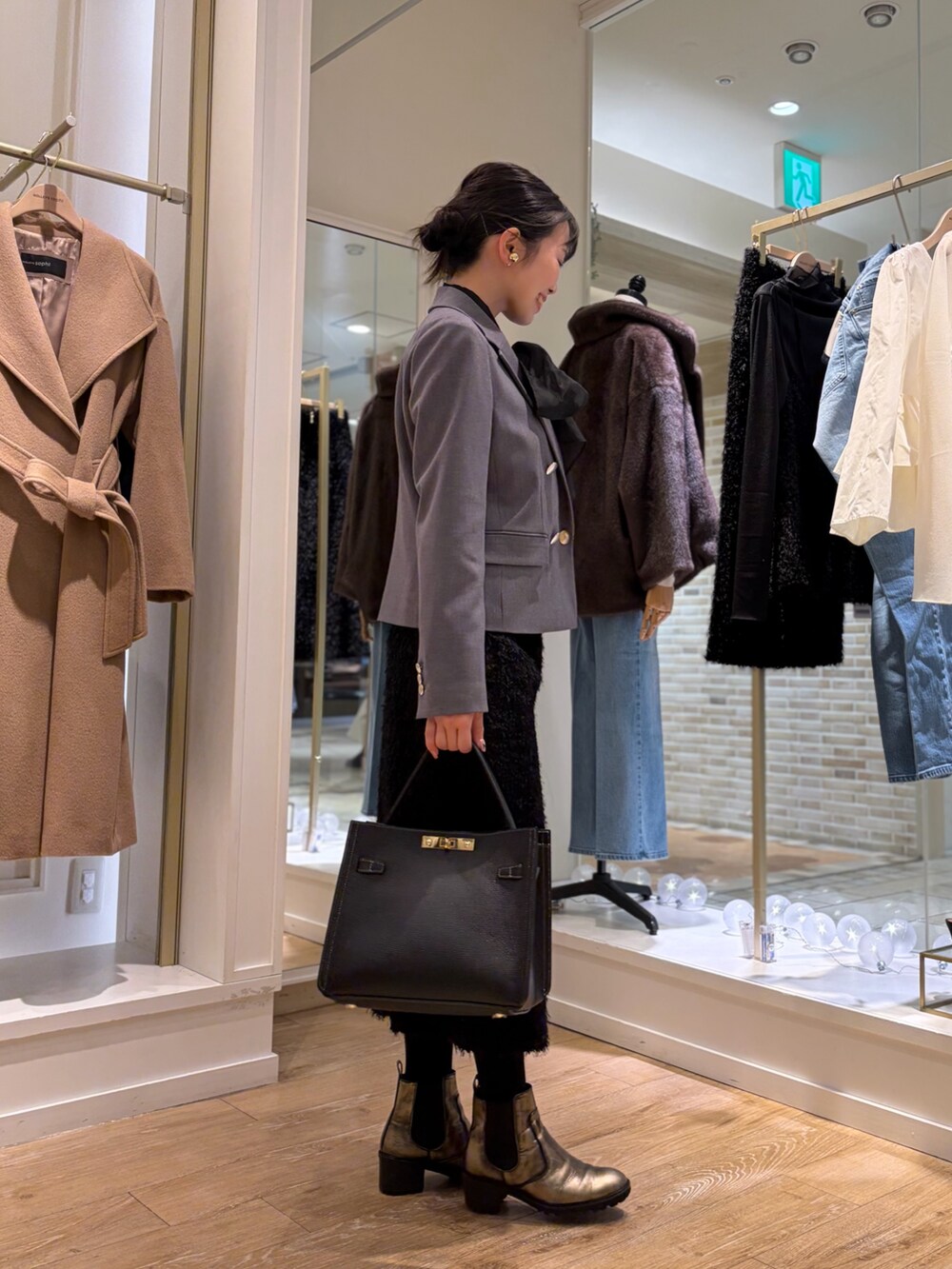 ブラック系のシャツ/ブラウス、グレー系のテーラードジャケット、ブラック系のスカートを着用したレディースの秋コーディネートの4枚目の写真