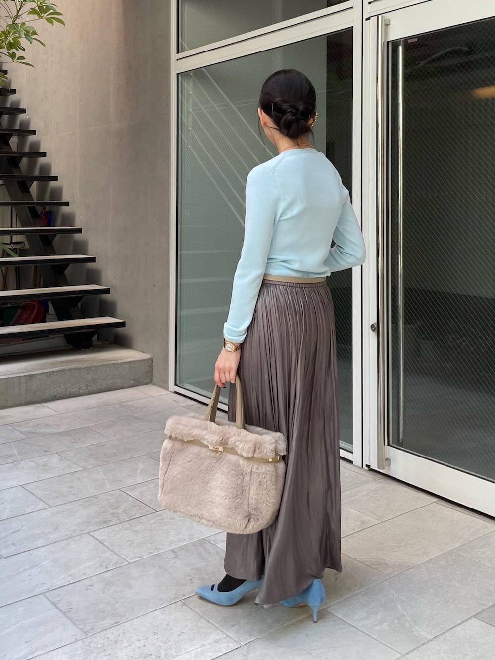 ブルー系のニット/セーター、グリーン系のスカート、ベージュ系のトートバッグを着用したレディースの秋コーディネートの2枚目の写真