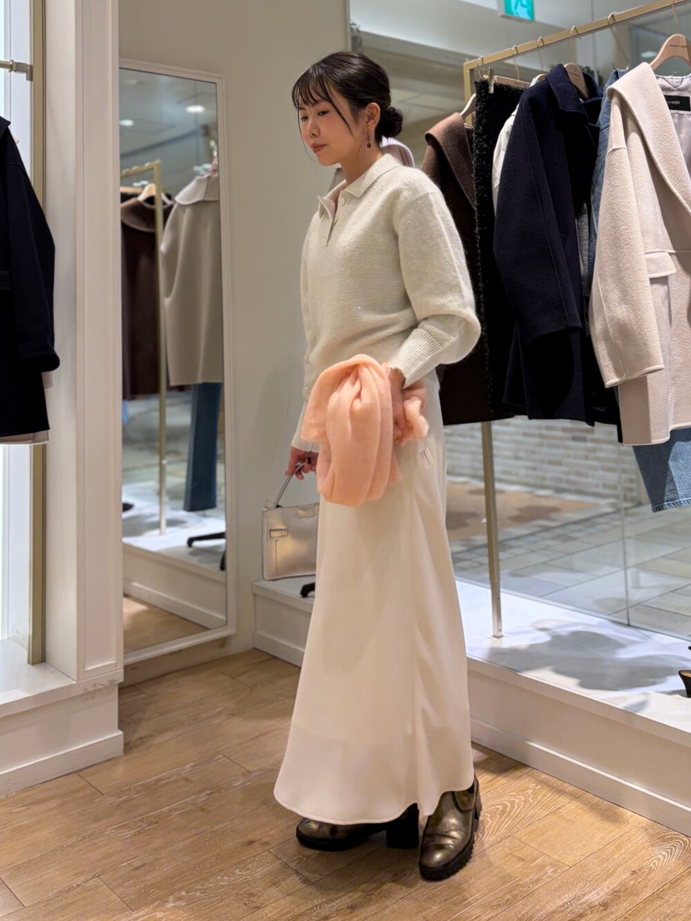 ホワイト系のニット/セーター、シルバー系のショルダーバッグ、ホワイト系のスカートを着用したレディースの秋コーディネートの2枚目の写真