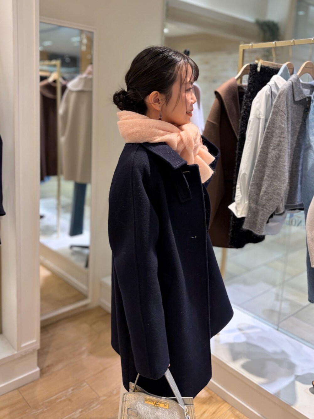 ホワイト系のニット/セーター、ホワイト系のスカート、ブルー系のステンカラーコートを着用したレディースの秋コーディネートの6枚目の写真